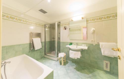 a bathroom with a bath tub and a sink at Hotel Iaccarino in SantʼAgata sui Due Golfi