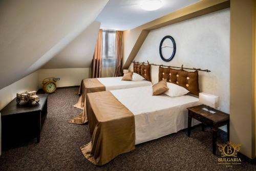 a bedroom with two beds and a mirror on the wall at Wellness Hotel Bulgaria in Bansko