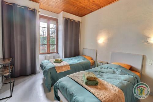 een kamer met 2 bedden en een raam bij Les trois etangs in Montreuil-sur-Ille
