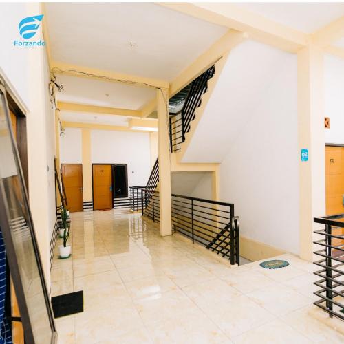 un couloir dans un bâtiment avec un escalier dans l'établissement FORZANDO HOUSE, à Sengkaling