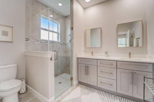 een witte badkamer met een douche en een toilet bij Sunny Haven Retreat in Englewood