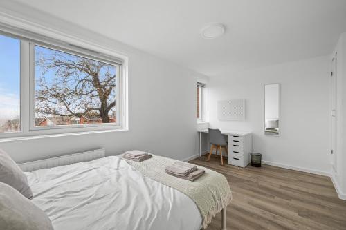 20% OFF Spacious 6 Bed Large Home w/ Free Parking في إكسيتير: غرفة نوم بيضاء بها سرير ونافذة