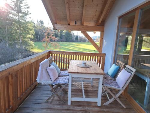 porche con mesa y sillas en la cubierta en Wolke 8 en Bernau am Chiemsee