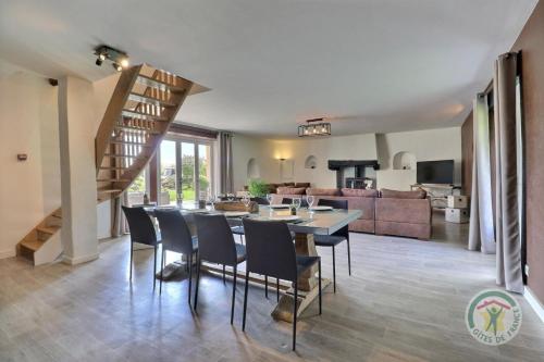 a dining room and living room with a table and chairs at La ville lesne in Montauban-de-Bretagne