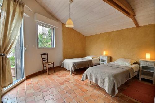 1 dormitorio con 2 camas y ventana en La haie chapeau en Saint-Thurial