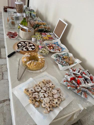 un tavolo con molti tipi diversi di cibo su di esso di B&B Il Mandorlo a San Vito