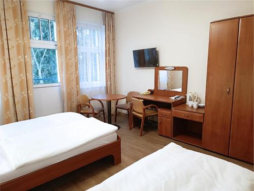 a room with two beds and a desk and a mirror at Willa Storczyk Polanica Zdrój in Polanica-Zdrój