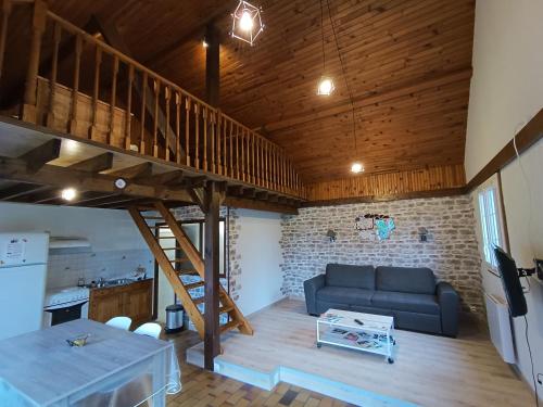een woonkamer met een bank en een loft bij Domaine de karoli in Barneville-sur-Seine