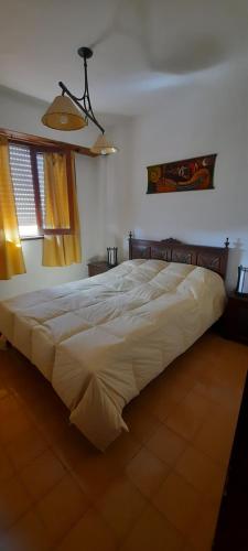 1 cama blanca grande en un dormitorio con ventana a DEPTO 2 CON COCHERA VILLA GESELL en Villa Gesell