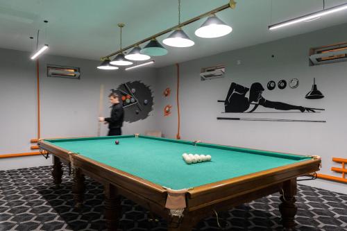 a man standing in a room with a pool table at Shoxjahon Hotel - 600 Mbps Internet in Tashkent