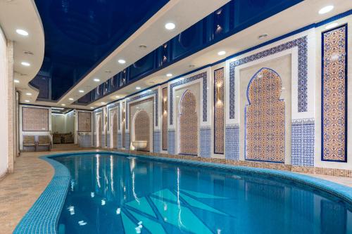 a swimming pool in a hotel with a tile wall at Shoxjahon Hotel - 600 Mbps Internet in Tashkent
