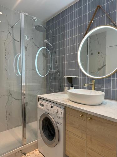 une salle de bain avec une machine à laver et un lavabo dans l'établissement Paris La Belle, à Paris
