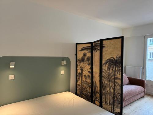 Schlafzimmer mit einem Bett mit Wandgemälde in der Unterkunft Paris La Belle in Paris