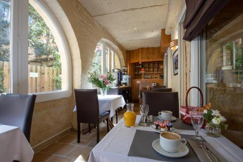 a dining room with two tables and a window at La Villa des Consuls - Gîte de tourisme de charme in Sarlat-la-Canéda