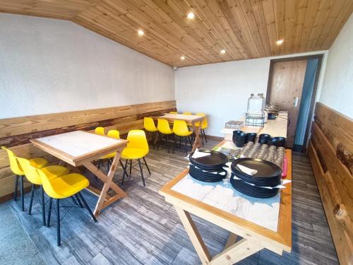 een restaurant met houten tafels en gele stoelen bij Hotel Wild Spring Mussoorie in Mussoorie