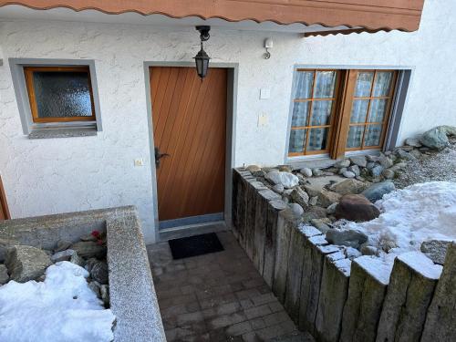 a front door of a house with snow on the ground at 250m zur Hannigalp und Bergpanorama in Grächen