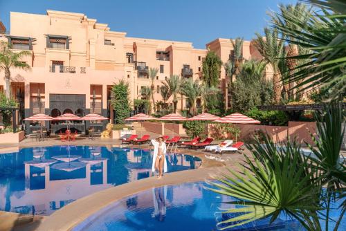 a woman standing in a pool at a hotel at Mövenpick Hotel Mansour Eddahbi Marrakech in Marrakesh