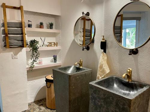 baño con lavabo y 2 espejos en La Kaz Caleepso, en La Possession