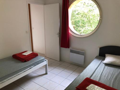 a small room with a bed and a window at Montaigu Plage in Montaigu-de-Quercy