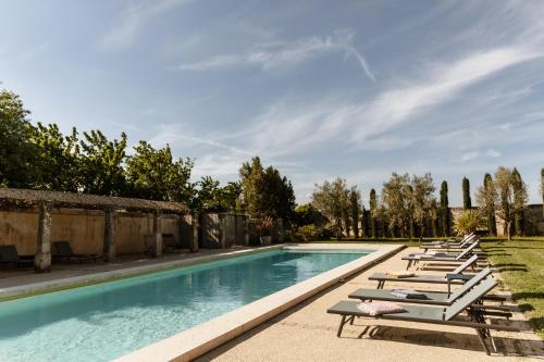 una fila de tumbonas y una piscina en Le Domaine de L'Osage, en Pont-Saint-Esprit