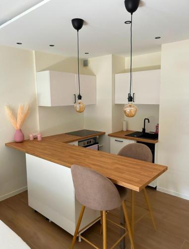 une cuisine avec une table en bois et deux chaises dans l'établissement Studio rénové au Suquet à Cannes, à Cannes