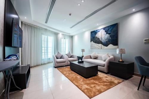 uma sala de estar com dois sofás e uma mesa em فنـــــــــدق ايليفــــــــــــار Elevar Hotel em Al Khobar