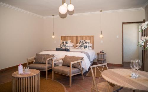 a bedroom with a bed and two chairs and a table at The Lofts @ Maple Square in Dullstroom