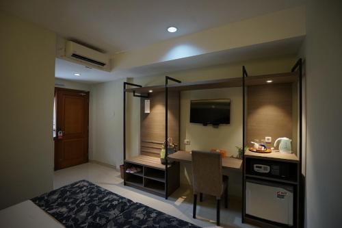 a hotel room with a bed and a desk in it at Hotel Sriti Magelang in Magelang