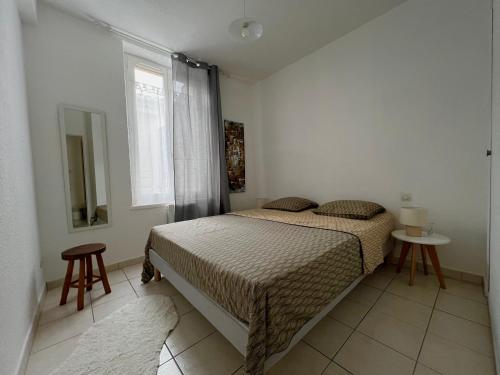 Habitación pequeña con cama y ventana en PETIT CAPUCIN, en Carcassonne