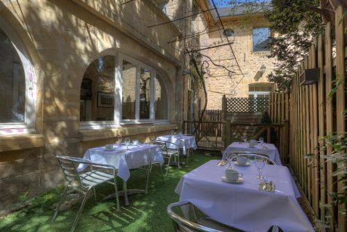 萨尔拉拉卡内达La Villa des Consuls - Gîte de tourisme de charme的建筑物内有桌椅的餐厅