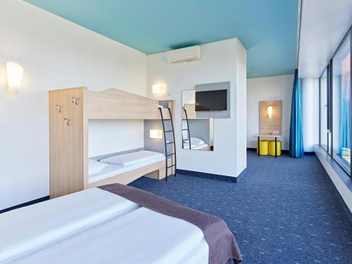 a room with a bed and a bunk bed at B&B HOTEL Münster Hafen in Münster