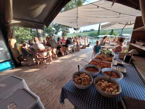 un buffet de comida en una mesa con gente sentada en Tenuta Tredici Ulivi, en Casa Albonetti