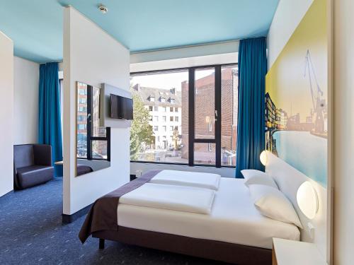 ミュンスターにあるB&B HOTEL Münster Hafenのベッドルーム1室(ベッド1台、大きな窓付)
