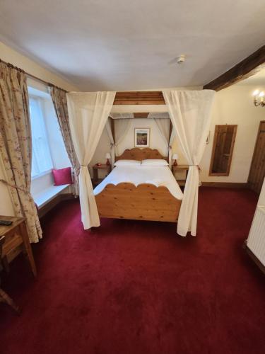ein Schlafzimmer mit einem großen Bett und einem roten Teppich in der Unterkunft The New Inn in Thornton Dale