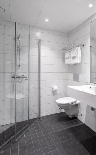 a bathroom with a shower and a toilet and a sink at Basecamp Narvik in Narvik