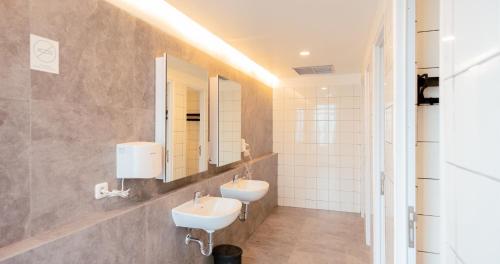 ein Badezimmer mit 2 Waschbecken und einem Spiegel in der Unterkunft Bobopod Airport CBC, Tangerang in Rawalembang