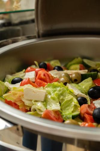 a bowl of salad with olives and lettuce at Shoxjahon Hotel - 600 Mbps Internet in Tashkent