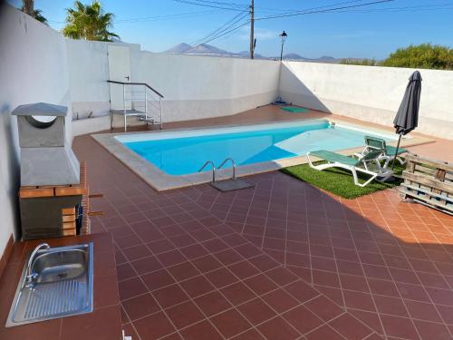 a swimming pool with a table and a chair next to it at Oasis house in Nazaret