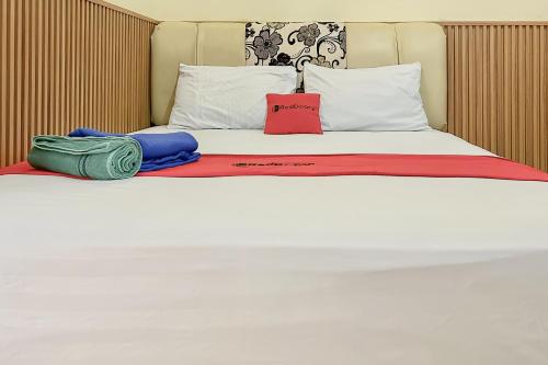 un letto bianco con due cuscini sopra di RedDoorz near Wisma Cahaya Abadi Sepinggan Aiport a Balikpapan