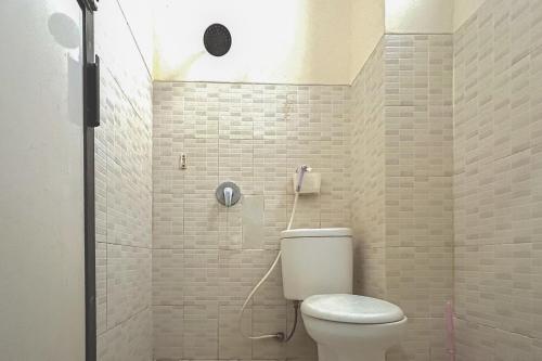 a bathroom with a toilet and a shower at RedDoorz near Wisma Cahaya Abadi Sepinggan Aiport in Balikpapan