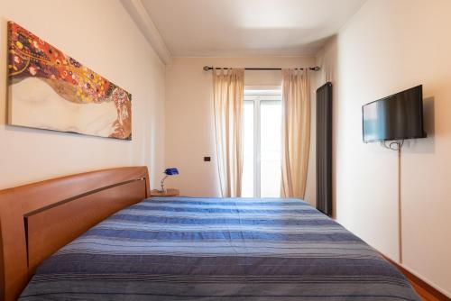 Schlafzimmer mit einem Bett und einem Flachbild-TV in der Unterkunft Suite Amendola-Luxury apartment in Bari