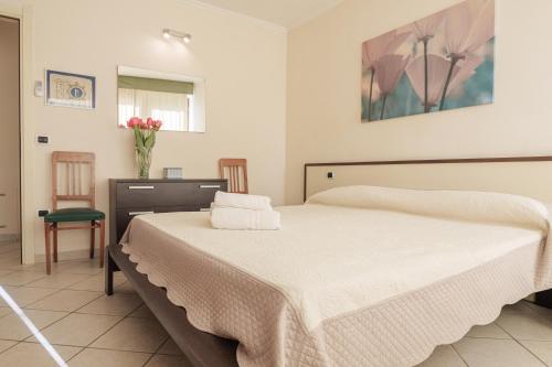 a bedroom with a bed and a vase of flowers at CASA NAVLA' AppartamentI "Ulivi"- "Fiori" -"Velieri"-"Luna"-"Nido"-"Taverna" in Tignale