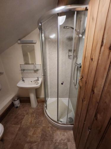 uma casa de banho com um chuveiro e um lavatório. em The New Inn em Thornton Dale