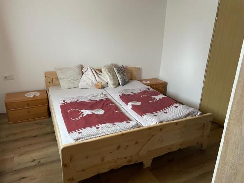 um quarto com uma cama de madeira e 2 almofadas em Ferienwohnung in ruhiger Lage in Bischofshofen em Bischofshofen