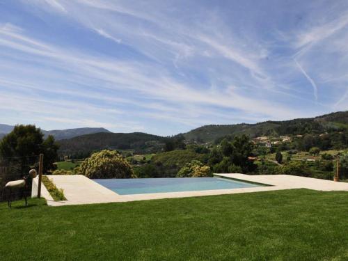 ポンテ・デ・リマにあるBeautiful Ponte de Lima Villa - 4 Bedrooms - Villa Hermosa Vista - Private Pool and Staggering Mountain Views - North Portugalの草の茂る庭のスイミングプールを眺めることができます。