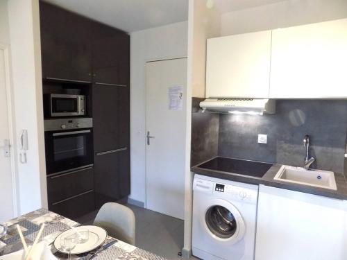 a kitchen with a washing machine and a sink at Royan - CONFORTABLE APPARTEMENT - TERRASSE et JARDINET PRIVATIF - WIFI in Royan