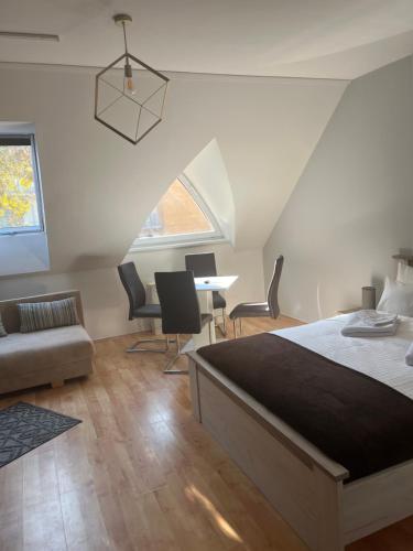 1 dormitorio con 1 cama, mesa y sillas en Grace Apartman, en Hajdúszoboszló
