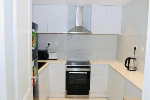 a kitchen with white cabinets and a black stove at Dubai Marina larivera in Dubai