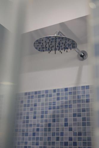a blue tiled shower with a shower head in a bathroom at CASA NAVLA' AppartamentI "Ulivi"- "Fiori" -"Velieri"-"Luna"-"Nido"-"Taverna" in Tignale