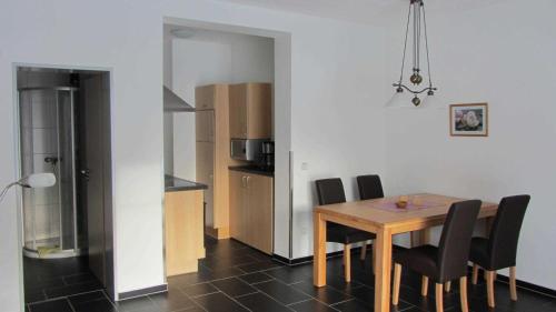 Neuenbau的住宿－Am Alten Forsthaus，一间带桌椅的用餐室和一间厨房